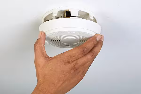 Expert technician ensuring smoke detector compliance for Melbourne commercial building